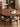 Made-to-order Earthy black walnut wood round table with four sturdy legs, showcasing natural wood grain and craftsmanship.